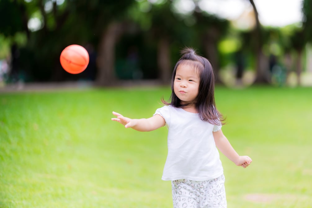 Little Girl Throwing a Ball